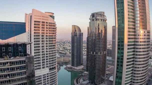 Gebouwen van Jumeirah Meren Torens na zonsondergang met verkeer op de weg dag tot nacht timelapse. — Stockvideo