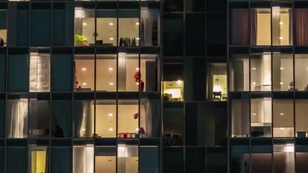 Window of the multi-storey building of glass and steel lighting and people within timelapse — Stock Video