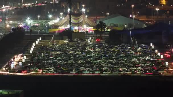 Forgalom egy nagy parkolóban Ajman légi kilátásban a tetőről, éjszaka.. — Stock videók