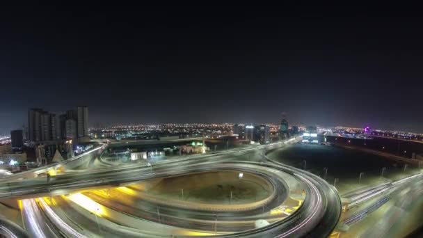 Verkeer op een grote weg kruising in Ajman luchtfoto van het dak 's nachts timelapse. — Stockvideo