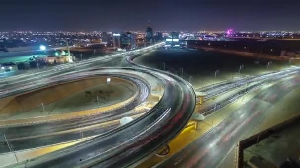 Trafic sur un grand carrefour routier à Ajman vue aérienne depuis le toit la nuit timelapse. — Video
