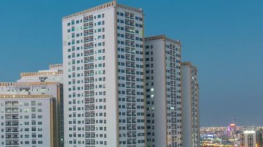 Ajman 'da çatıdan gece saatine kadar kuleleri olan şehir manzarası. Birleşik Arap Emirlikleri.