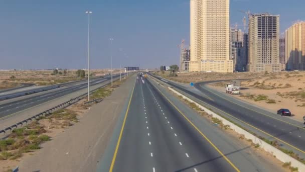 Dálnice silnice s dopravní timelapse ve velkém městě od Ajman do Dubaje před západem slunce. Dopravní koncepce. — Stock video