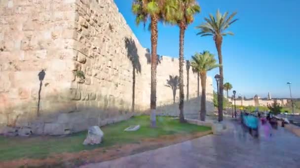 Defensive wall of the ancient holy Jerusalem timelapse hyperlapse, lit by the bright sun. Wonderful green lawn — Stock Video