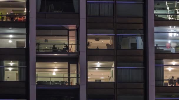 Grandes janelas brilhantes em escritórios modernos e edifícios residenciais timelapse à noite — Vídeo de Stock