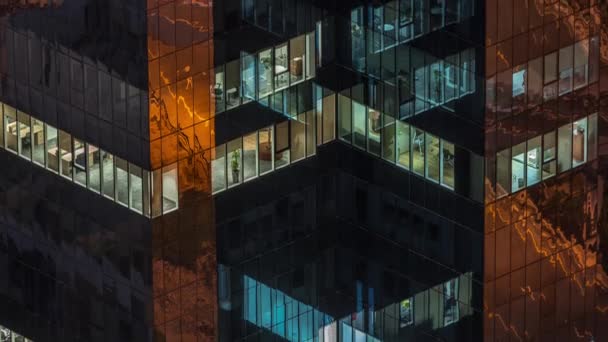 Ventanas en el exterior del edificio de oficinas en la noche con luces interiores en timelapse — Vídeos de Stock