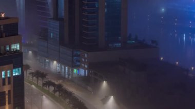 Binalar Business Bay 'de gece vakti yoğun sis tabakasıyla kaplıdır..
