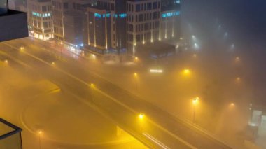 Binalar Business Bay 'de gece vakti yoğun sis tabakasıyla kaplıdır..