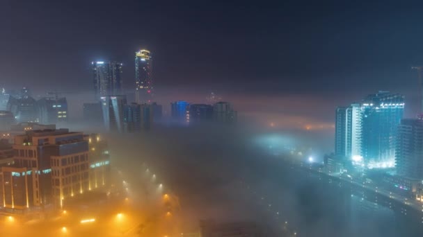 Gli edifici sono ricoperti da uno spesso strato di nebbia nel timelapse notturno di Business Bay. — Video Stock
