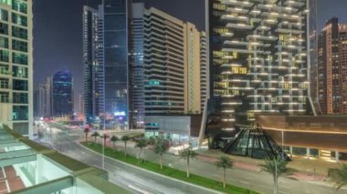Business Bay bölgesinde modern şehir mimarisi. Dubais gökdelenlerinin panoramik görüntüsü gece zaman ayarlı