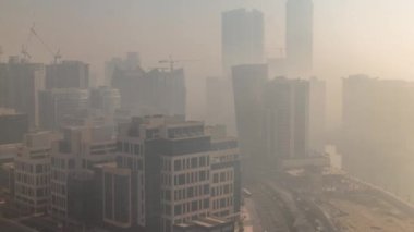 Gündoğumunda Business Bay bölgesinde modern şehir mimarisi. Dubais gökdelenlerinin panoramik görüntüsü sisli sabah zamanı