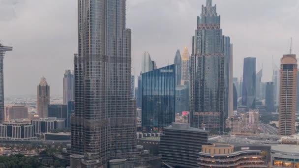 Rascacielos que se elevan por encima del centro de Dubai día a noche timelapse rodeado de modernos edificios vista aérea — Vídeo de stock