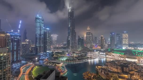 Pencakar langit naik di atas Dubai pusat kota malam pasang surut dikelilingi oleh bangunan modern pemandangan atas udara — Stok Video