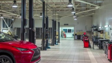 Otomobil asansörleri modern servis istasyonu içinde hareket eder ve erkekler arabalar timelapse onarma.