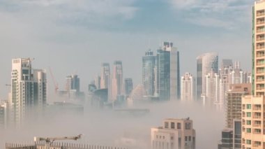 Dubai 'deki gökdelenler, güneş doğarken iş sahasında sisle kaplıydı..