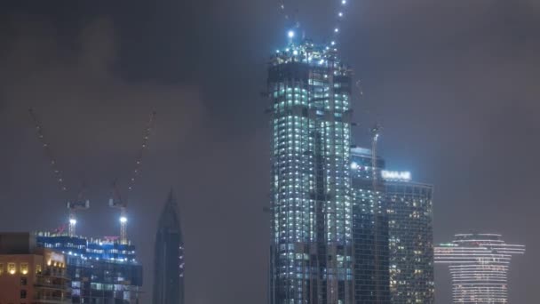 Żurawie pracujące nad nowoczesnym terenem ograniczającym prace nowych drapaczy chmur w nocy timelapse — Wideo stockowe