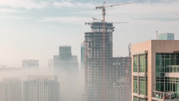 Дубайські хмарочоси, вкриті ранковим туманом в діловому районі бухти під час сходу сонця.. — стокове відео