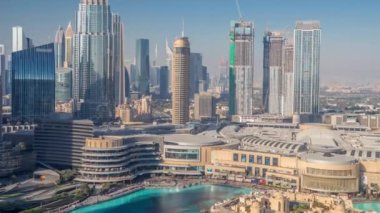 Dubai şehir merkezinden yükselen gökdelenler, alışveriş merkezleri ve çeşmeler modern binalarla çevrili.