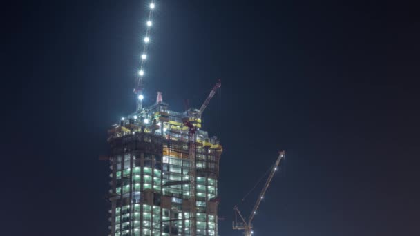 Guindastes trabalhando em obras modernas do site de construção de novo arranha-céu noite timelapse — Vídeo de Stock