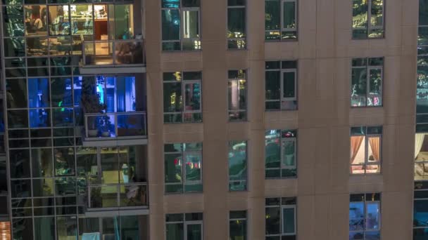 Fönster i höghus exteriör i slutet av kvällen med interiör lampor på timelapse — Stockvideo