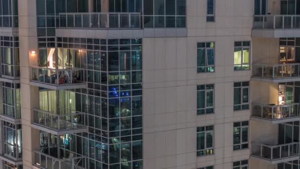 Ventanas en el exterior del edificio de gran altura al final de la noche con luces interiores en timelapse — Vídeo de stock