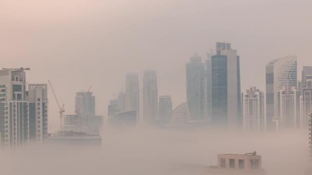 Grattacieli di Dubai coperti da nebbia mattutina nel quartiere business bay durante l'alba timelapse. — Video Stock
