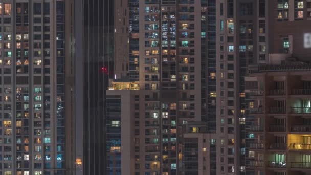Janelas no exterior do edifício de arranha-céus no final da noite com luzes interiores na timelapse — Vídeo de Stock