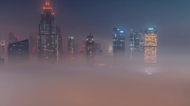 空中からの眺め朝の霧がドバイ国際金融センター地区の夜から昼の時間経過を覆いました — ストック動画