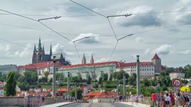 Czerwony tramwaj przejeżdżający na Manes Bridge timelapse i słynny Zamek Praski na tle Pragi, Czechy. — Wideo stockowe