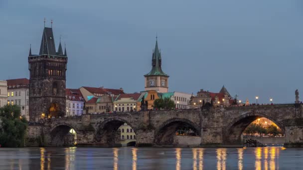 Die Karlsbrücke Tag-Nacht-Zeitraffer über die Moldau spiegelt sich im Wasser in Prag, Tschechische Republik — Stockvideo