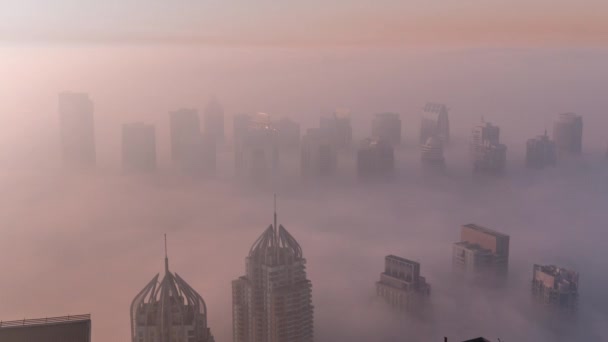 Mgła pokrywała wieżowce JLT i wieże mariny w pobliżu Sheikh Zayed Road w czasie wschodu słońca. Budynki mieszkalne — Wideo stockowe