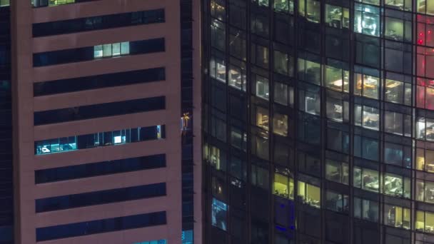 Janelas no exterior do edifício de arranha-céus no final da noite com luzes interiores na timelapse — Vídeo de Stock