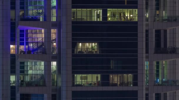 Ventanas en el exterior del edificio de gran altura al final de la noche con luces interiores en timelapse — Vídeos de Stock