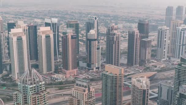 Rascacielos deportivos JLT y Dubai cerca de Sheikh Zayed Road durante el día y la noche. Edificios residenciales — Vídeos de Stock