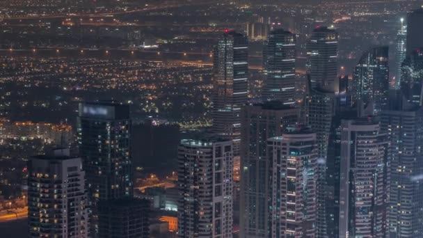 Rascacielos JLT cerca de Sheikh Zayed Road timelapse noche aérea. Edificios residenciales — Vídeos de Stock