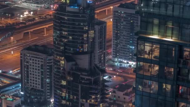 Futuristische gebouwen van Dubai met metrostation en luxe wolkenkrabbers achter in de buurt van Dubai Marina nacht timelapse — Stockvideo