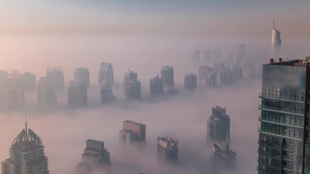 Nebelschwaden überzogen JLT-Wolkenkratzer und Marina-Türme in der Nähe der Sheikh Zayed Road im Zeitraffer nach Sonnenaufgang. Wohngebäude — Stockvideo
