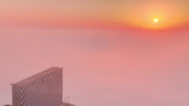 Dubai Marina silueti üzerinde nadir kış sisi ve güneşli hava saatleriyle aydınlatılan gökdelenler..