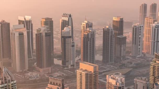 Rascacielos JLT y torres marinas cerca de Sheikh Zayed Road timelapse aéreo durante el amanecer. Edificios residenciales — Vídeo de stock