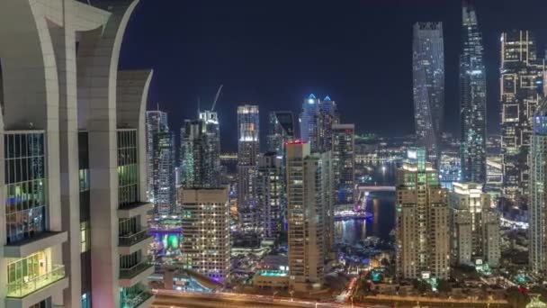 Небоскрёбы Dubai Marina рядом с перекрестком на Шейх-Заид-роуд с высокими жилыми зданиями ночного видения — стоковое видео