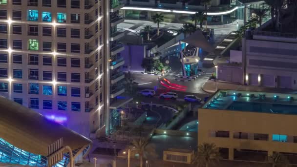 Avfart från tunnelbanestationen och trafik på en väg i Dubai marina natt timelapse — Stockvideo