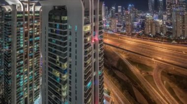 Dubai marinası ve JLT gökdelenlerinin hava manzarası. Parlayan camları olan gece vakti Sheikh zayed yolunda trafik vardı..