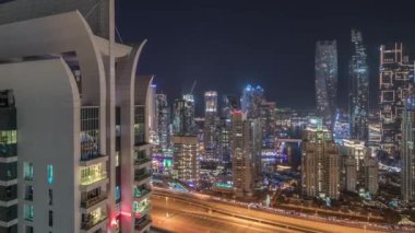 Dubai marinası ve JLT gökdelenlerinin hava manzarası. Parlayan camları olan gece vakti Sheikh zayed yolunda trafik vardı..