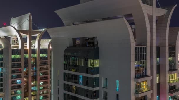 Luftaufnahme von JLT und Dubai Yachthafen Wolkenkratzer mit glühenden Fenstern Zeitraffer Nacht mit Verkehr auf Scheich zayed Straße. — Stockvideo
