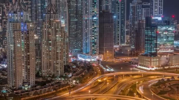 Vista aérea de Dubai Marina con gran cruce de carreteras noche timelapse y rascacielos alrededor, Emiratos Árabes Unidos — Vídeo de stock