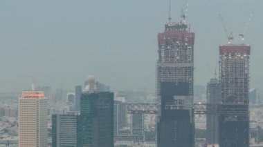 Dubai 'deki Dünya Ticaret Merkezi ile gökdelenlerin gece gündüz görüntüsü.