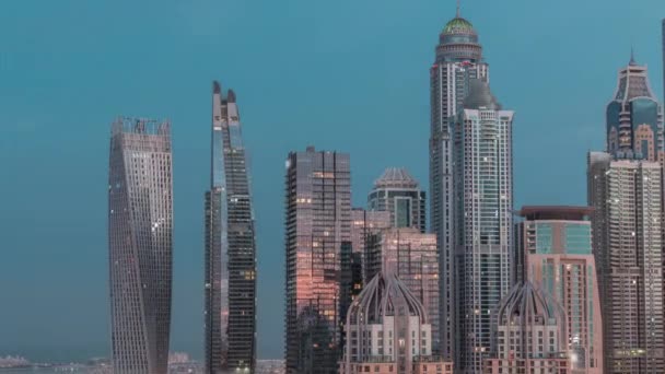Небоскрёбы Дубайской пристани рядом с перекрестком на Шейх-Заид-роуд с высокими жилыми зданиями ночью и днем — стоковое видео