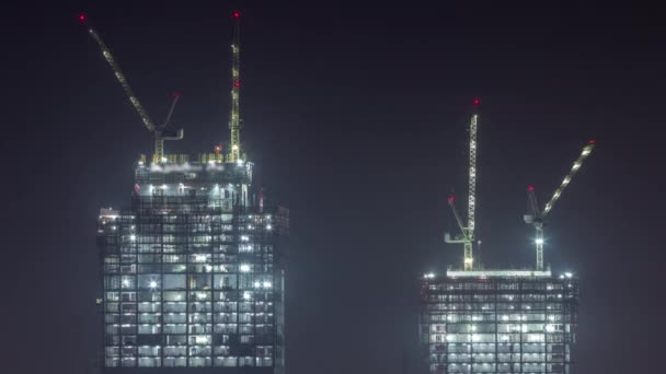 Gru che lavorano di notte su lavori di cantiere di vincolo moderni di nuovo timelapse di grattacielo — Video Stock