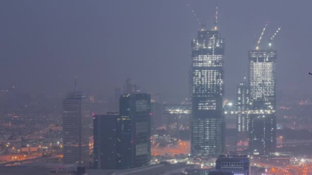 Flygfoto över skyskrapor med World Trade Center i Dubai natt till dag timelapse. — Stockvideo