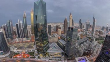 Dubai 'deki finans bölgesi iş merkezindeki fütüristik gökdelenlerin panoraması gece gündüz